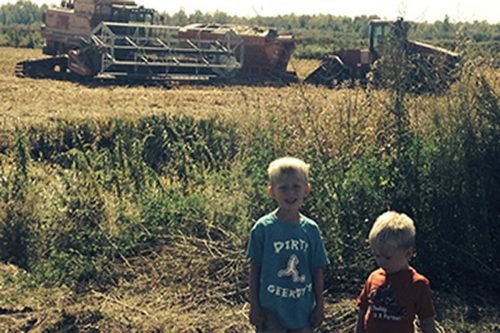 Family photo in front of Battle River Wild Rice equipment on the farm